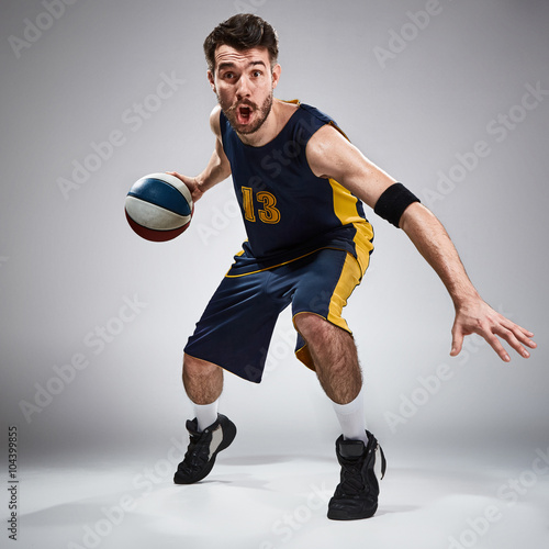 Full length portrait of a basketball player with ball 