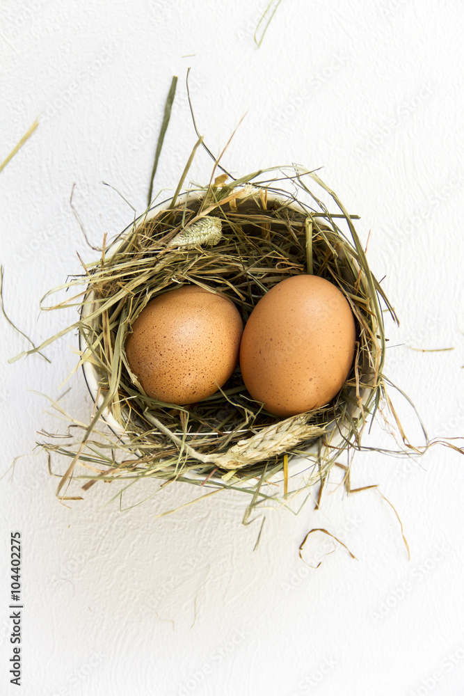 Easter egg in a black bowl with white dot, hay. White background. Easter egg in a black bowl with white dot, hay. White background.