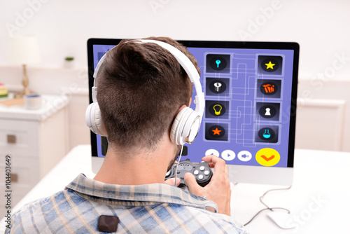 Young man playing computer ...