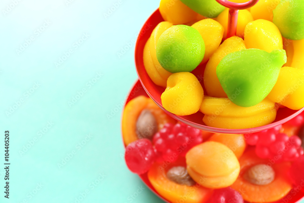 Fruit candies on stand on turquoise background