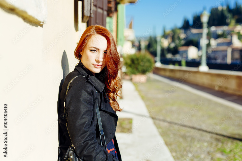 Italy, Verona, portrait of young woman leaning against house wall in sunlight Italy, Verona, portrait of young woman leaning against house wall in sunlight