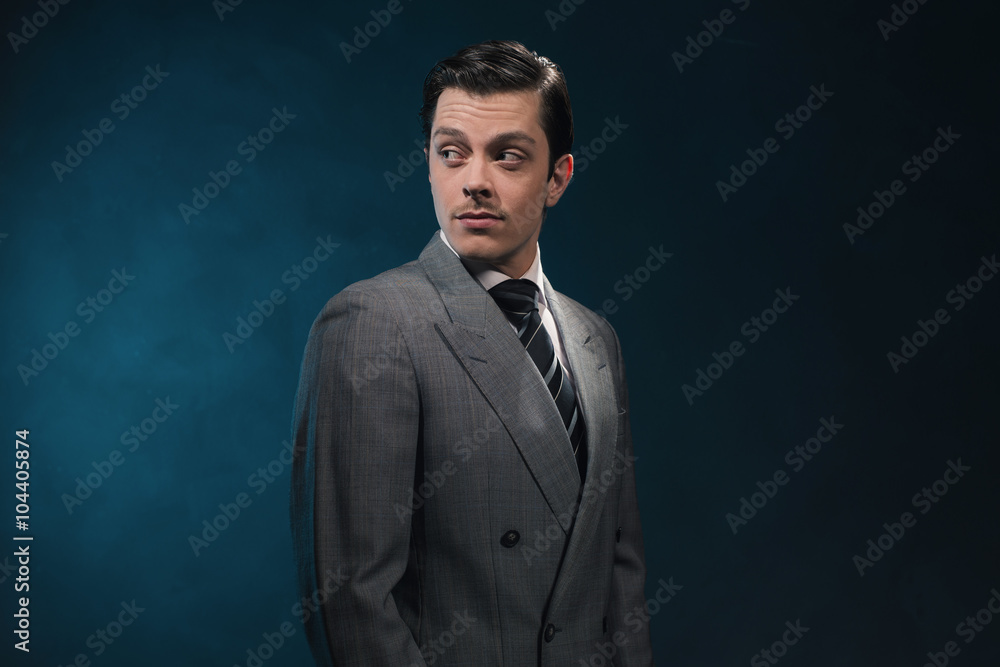 Retro 1940s business man in suit and tie against blue wall. Retro 1940s business man in suit and tie against blue wall.