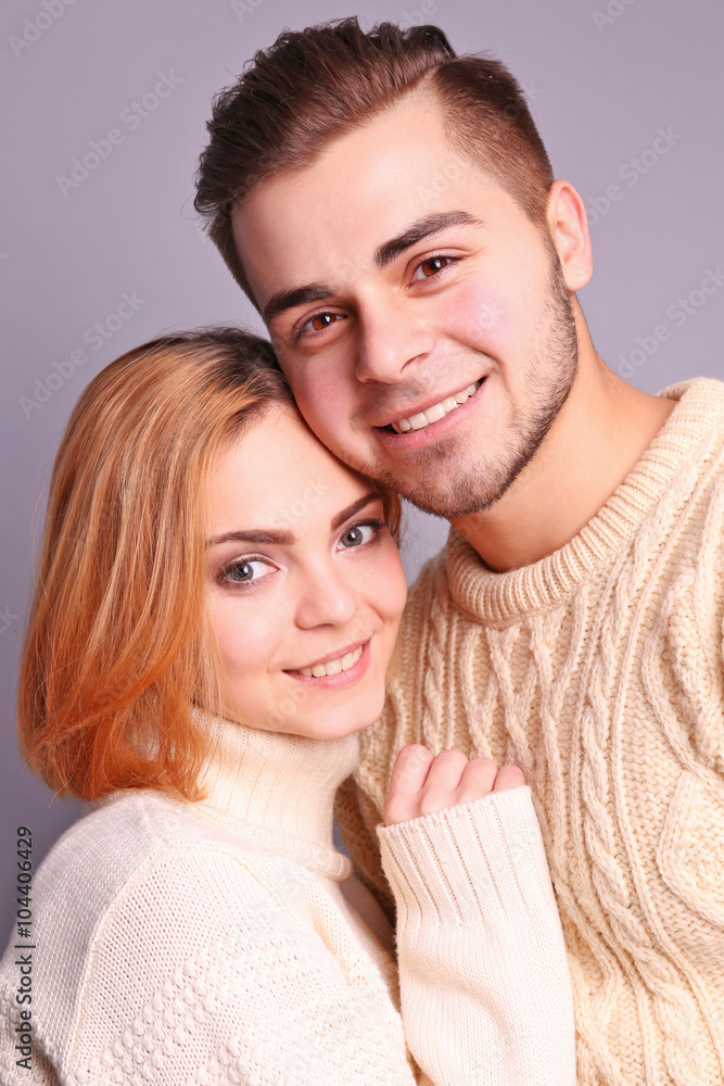 Young couple in love embracing on grey background, close up Young couple in love embracing on grey background, close up