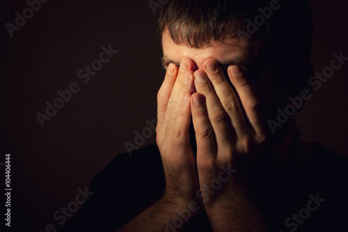 Man in depression, hands covered his face