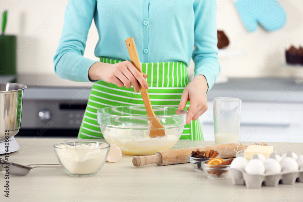 Young woman mixing dough in a bowl Young woman mixing dough in a bowl
