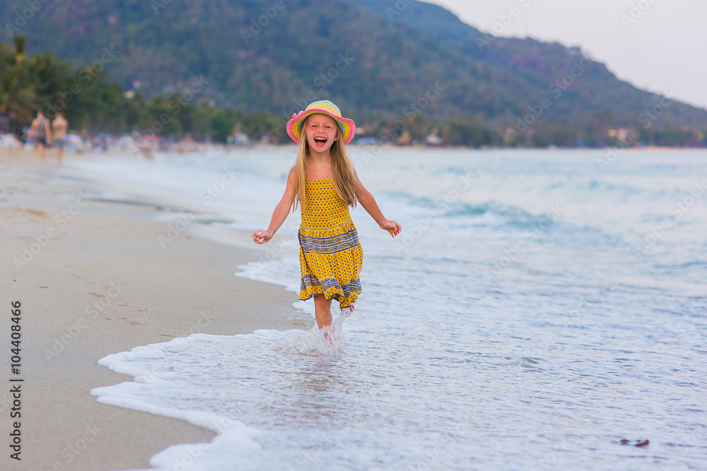 Счастливая девочка бежит по берегу моря