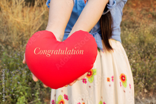 Women hand gently hold red heart with text congratulation photo