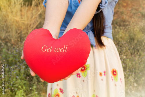 Women hand gently hold red heart with text get well photo