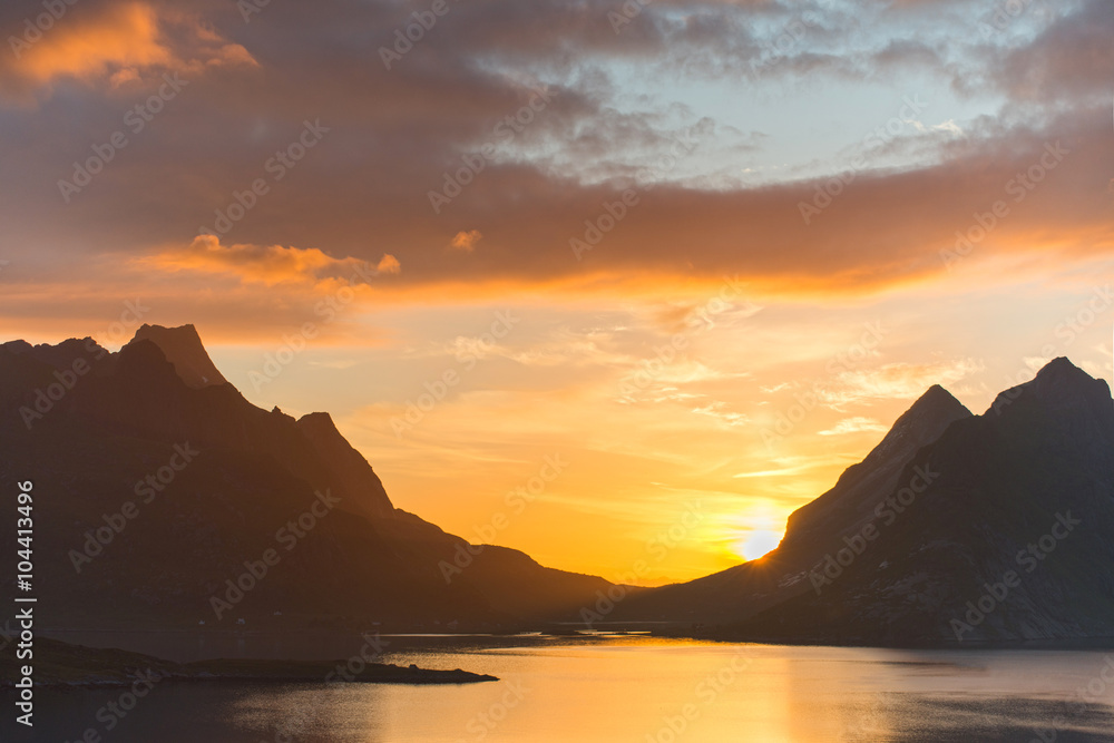 Beautiful sunset near the great mountains and clear silence water at Reine, Lofotens. Amazing nature of Norway. Cloudscape
