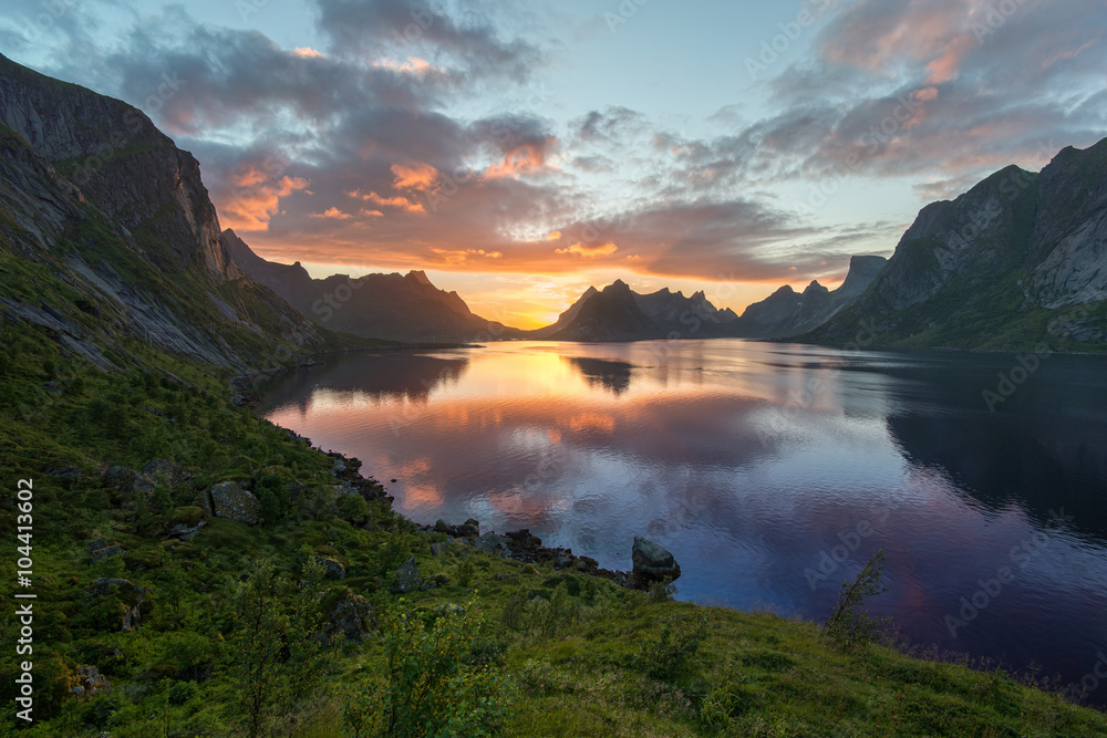 Beautiful sunset near the great mountains and clear silence water at Reine, Bunesfjorden, Lofotens. Amazing nature of Norway. Cloudscape