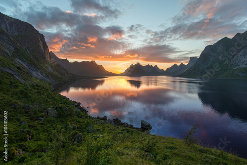 Beautiful sunset near the great mountains and clear silence water at Reine, Bunesfjorden, Lofotens. Amazing nature of Norway. Cloudscape © GavranBoris