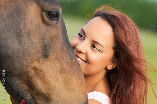 Unique portrait of curly girl loving and hugging her horse