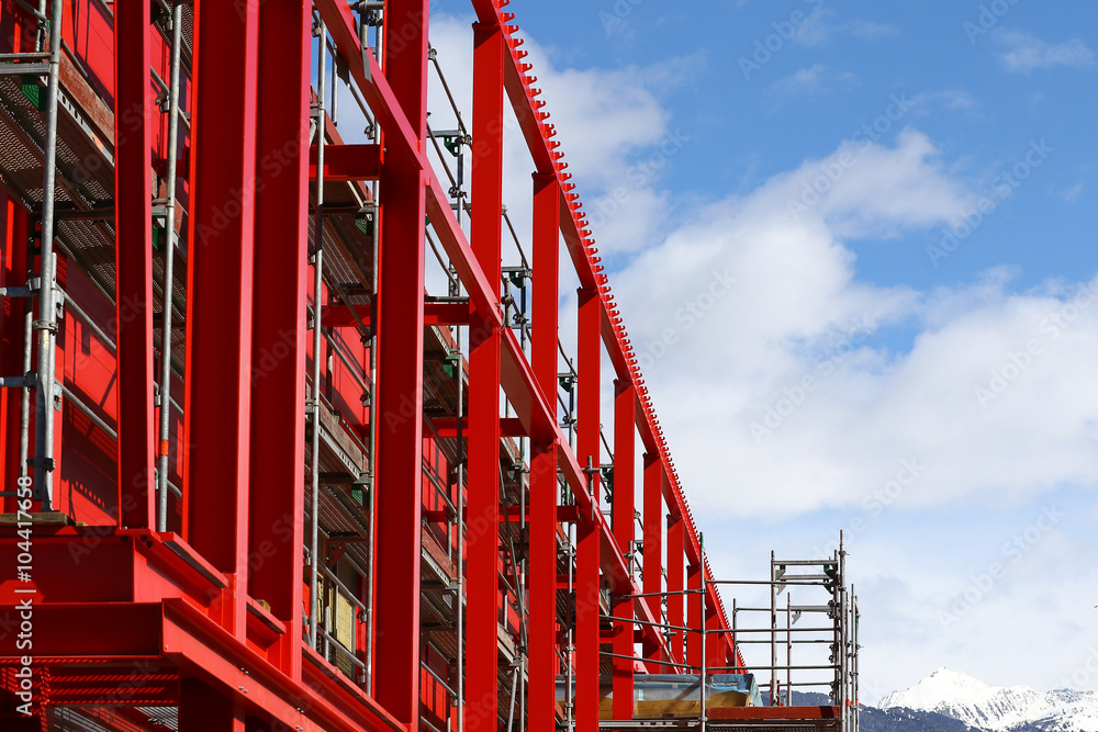 New steel beam construction being built against blue skies and white clouds New steel beam construction being built against blue skies and white clouds