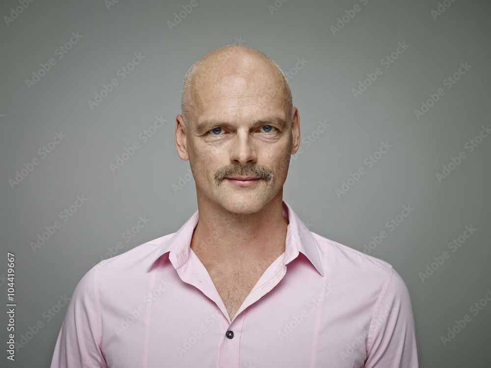 Portrait of bald man with moustache wearing pink shirt Portrait of bald man with moustache wearing pink shirt