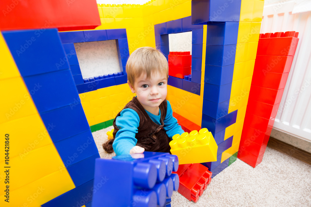 Pleased kid boy playing toy blocks Pleased kid boy playing toy blocks