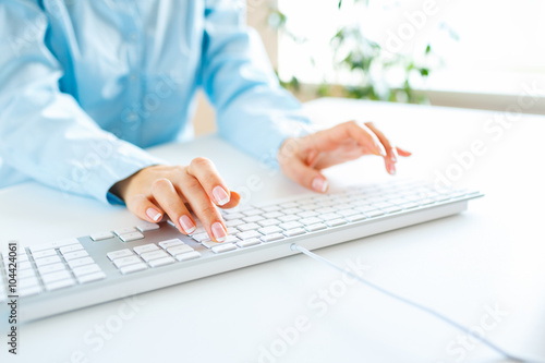 Woman office worker typing on the keyboard © vladstar