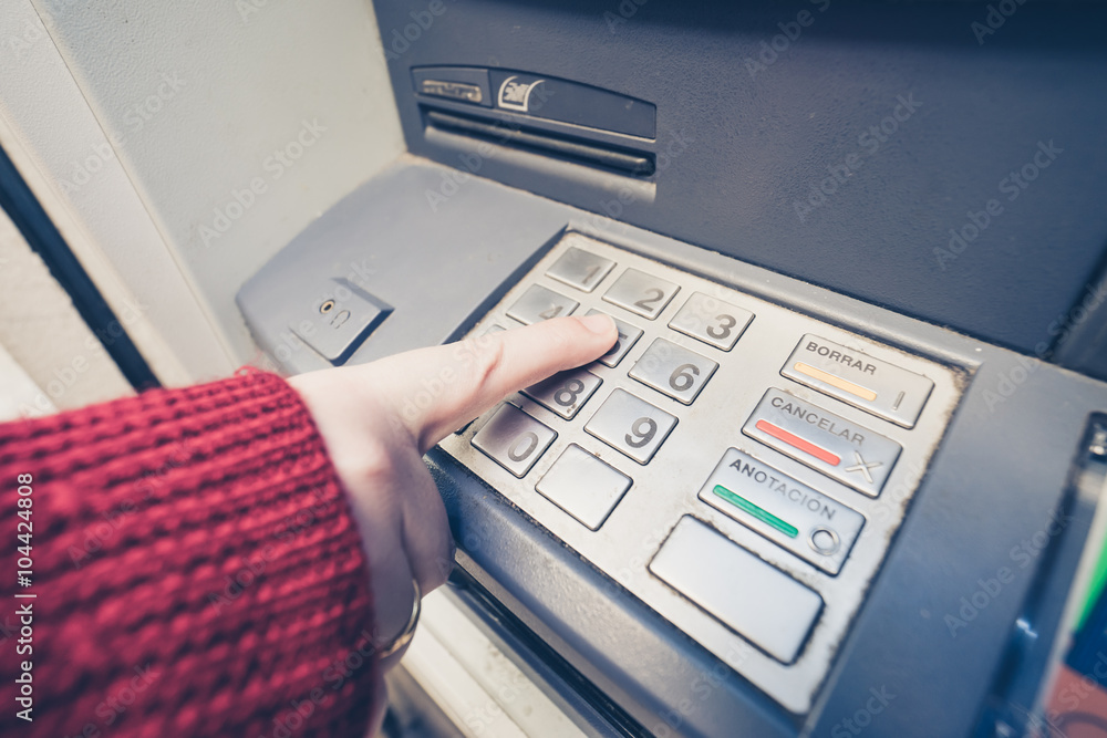 Close-up of woman's hand pushing button on atm Close-up of woman's hand pushing button on atm