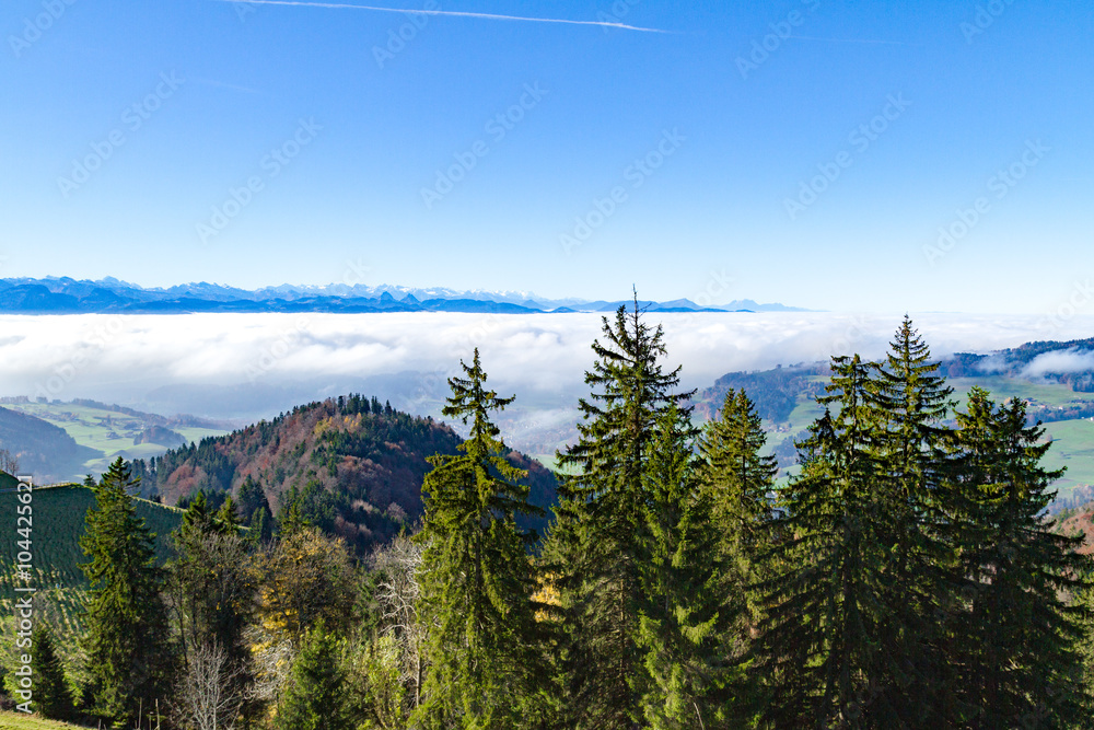 Panoramic cloudscape skyline view of Swiss Alps in blue sky.