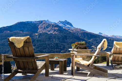 Wooden easy chairs at a mountain lodge terrace, Klosters Switzer photo