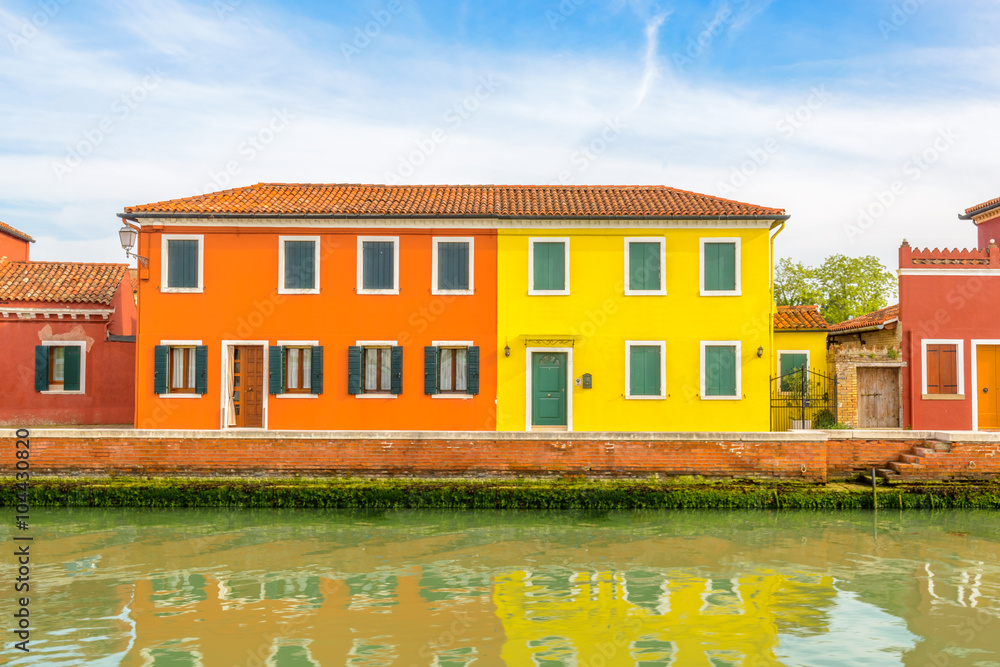 Colorful apartment building with nice waterfront view in Burano, Venice, Italy.