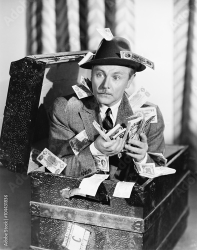 Quadro em tela Man sitting in a trunk with money in his hands