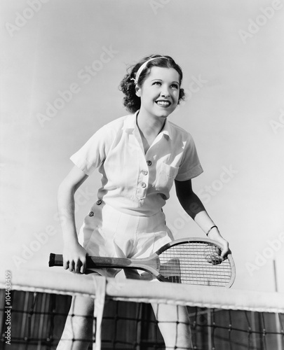 Portrait of female tennis player at the net 