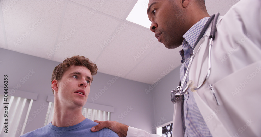 Obraz premium Young adult male patient talking with medical physician