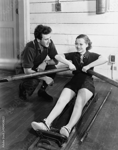 Photo Man with woman using rowing machine