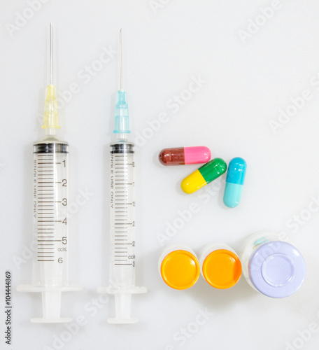 The syringe and tablet medicine on white background