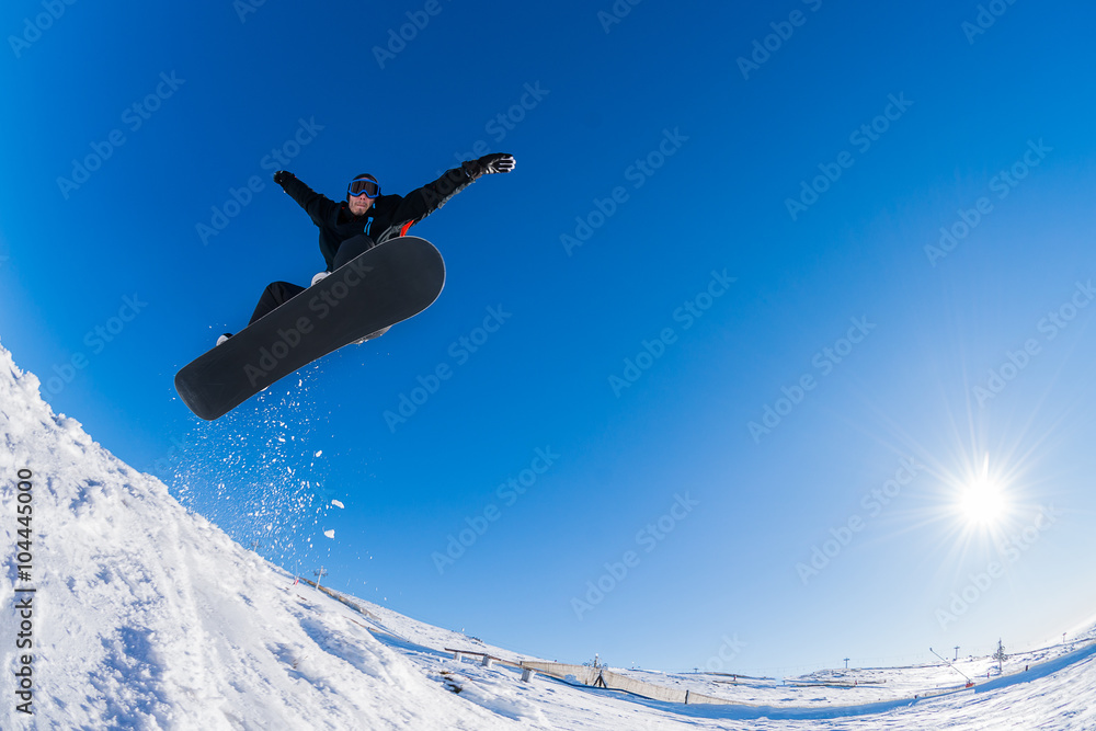 Snowboarder jumping against blue sky Snowboarder jumping against blue sky