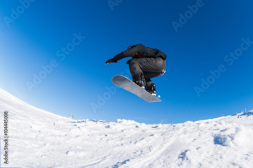 Snowboarder jumping against blue sky © homydesign