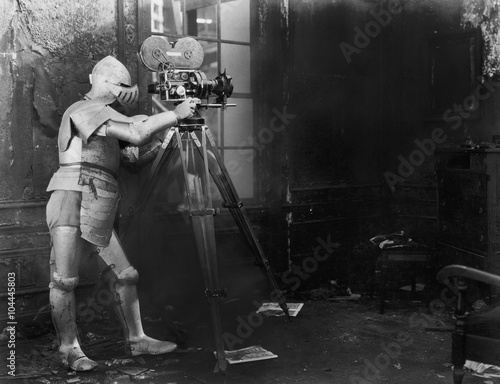 Knight at the movies, a man in an armored suit uses a film camera 