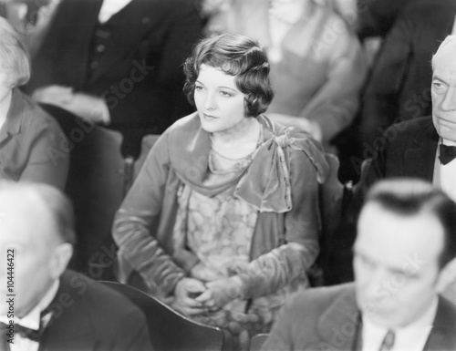 Woman sitting in a auditorium listening with folded hands  © everettovrk