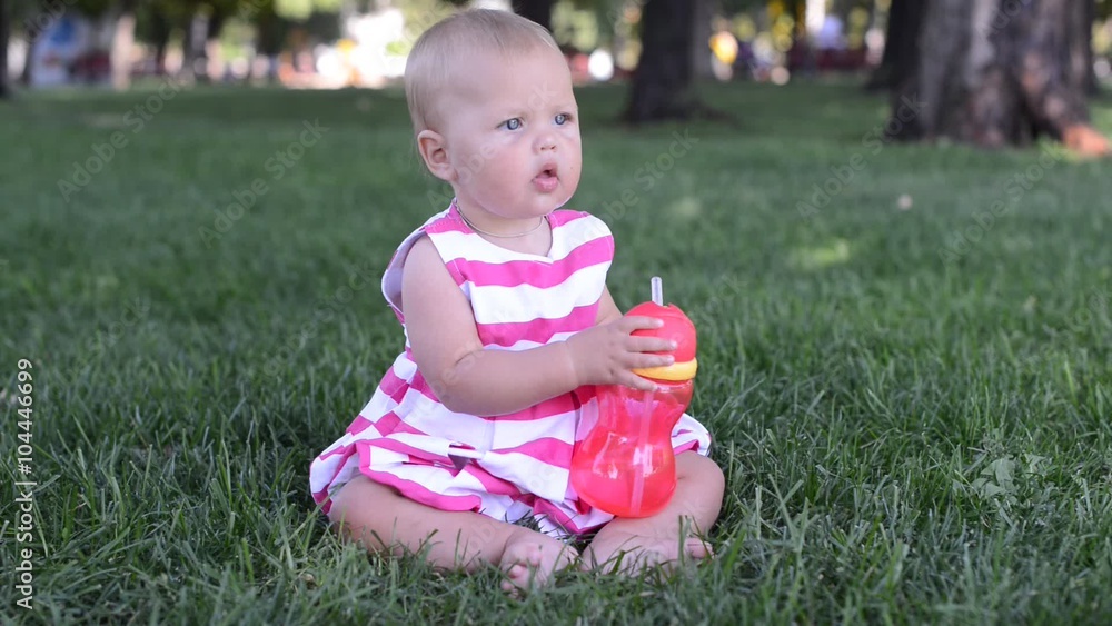 Happy baby plays with toys on fresh green grass of meadow Happy baby plays with toys on fresh green grass of meadow