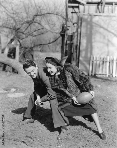 Couple playing football with each other 