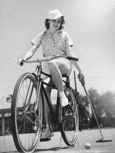 Woman on a bicycle playing polo 