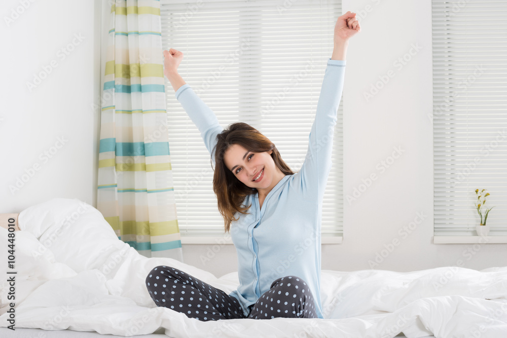 Young Woman Stretching Her Arms On Bed Young Woman Stretching Her Arms On Bed