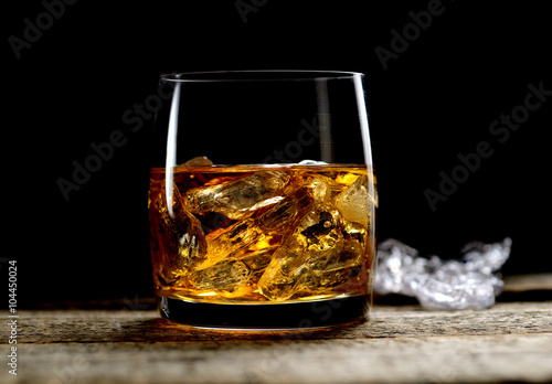 whiskey with ice on a wooden background
