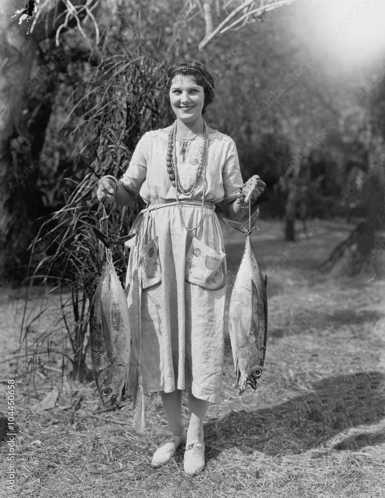 Young woman holding two huge fish 