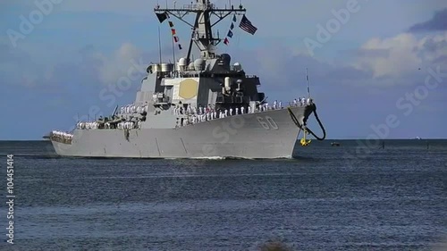 A guided missile destroyer Navy ship sails into port.