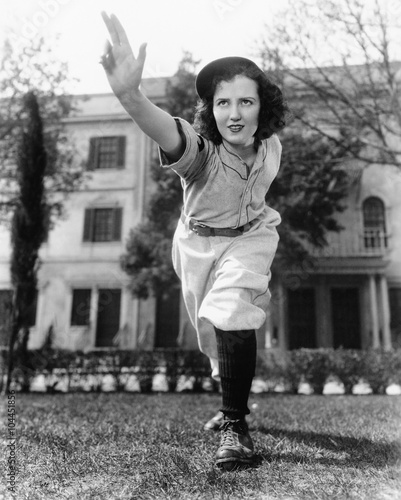 Canvas Print Young woman in baseball uniform throwing a ball