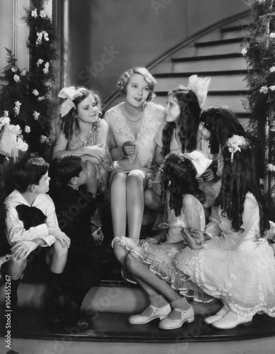 Woman singing with children on staircase at Christmas 