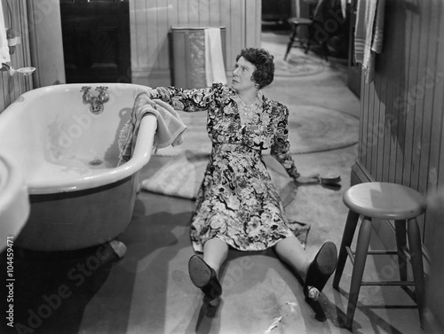 Fallen woman on floor next to bathtub  photo