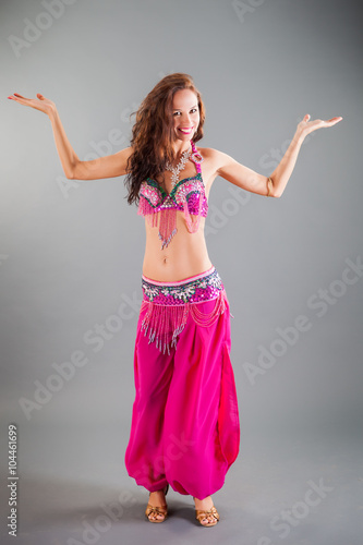 Slim Girl in Purple Orient Dance Costume Poses