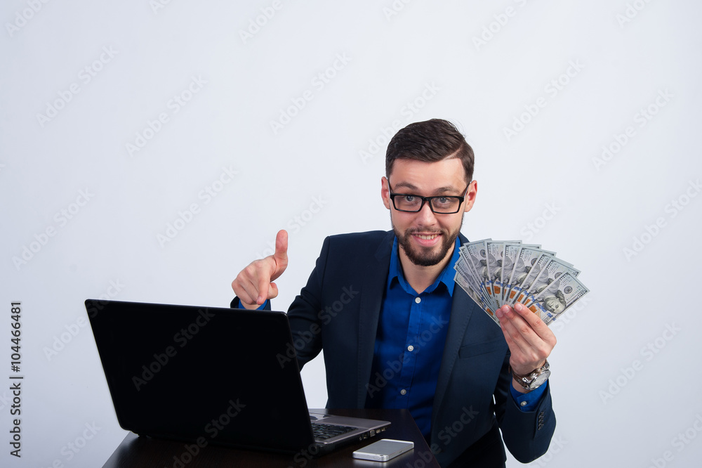Young man with dollars and laptop Young man with dollars and laptop