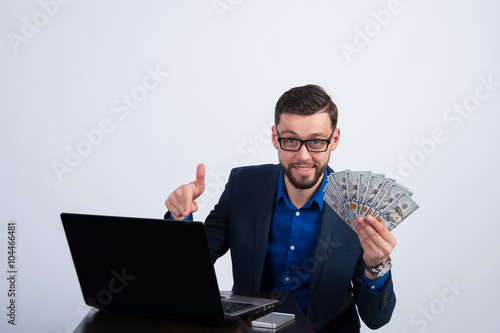 Young man with dollars and laptop