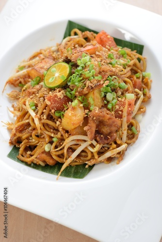 Asian style spicy fried noodles, ready to serve on dining table.