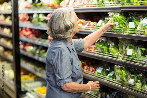 Foto Senior woman picking out some vegetables