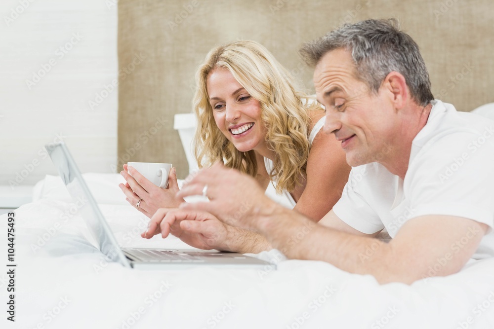 Cute couple using laptop in bed Cute couple using laptop in bed