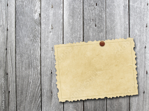 Close-up of one vintage postcard with pin on monochrome vertical wooden boards background
